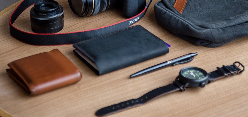 Wallets, pen and watch on wooden desk