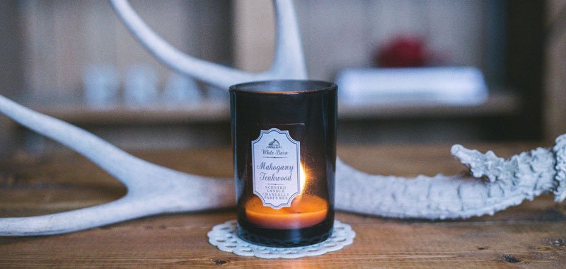 Candle on wooden table with deer antlers