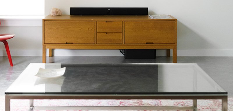 Glass coffee table infront of wooden console