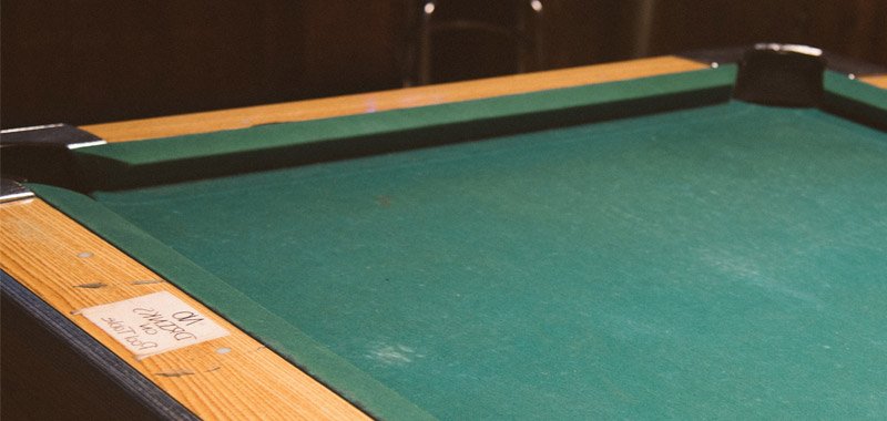 Empty snooker table with green cloth and wooden sides
